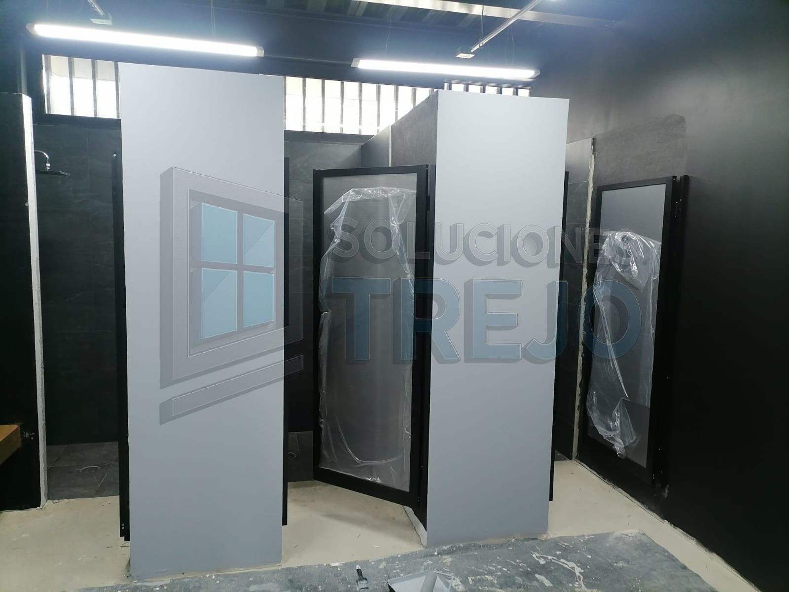 puertas de aluminio negro y policarbonato gris plata, instalación profesional de canceles para baños públicos en Guadalajara.